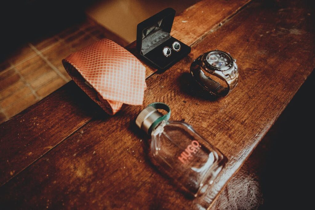 テーブルに置かれた、ネクタイ、カフス、腕時計、香水